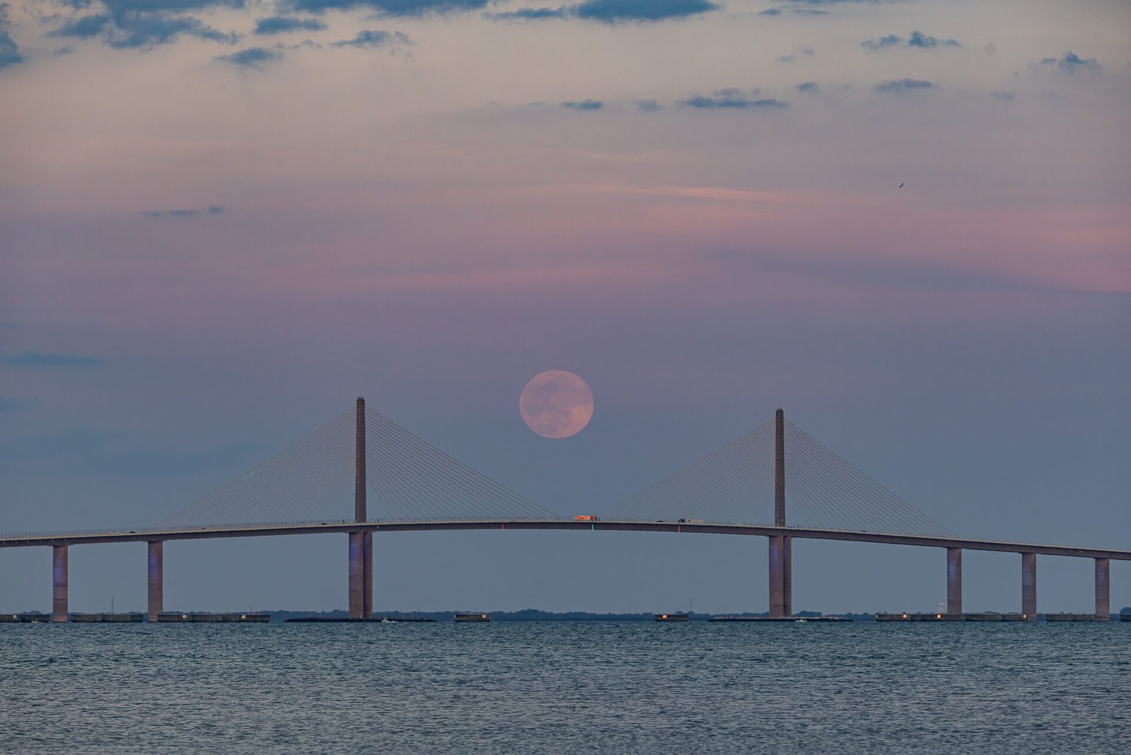 Super Moon Rising Between Spans Of Sunshine Skyway Bridge